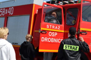 Zdjęcie przedstawia uczestników Operacji Czysta Rzeka wsiadających do wozu strażackiego