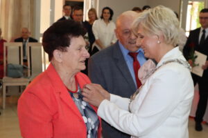 Zdjęcie przedstawia Burmistrza Miasta i Gminy Osjaków wręczającą medal za długoletnie pożycie małżeńskie Prezydenta Rzeczpospolitej Polskiej jubilatom