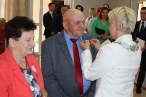 Zdjęcie przedstawia Burmistrza Miasta i Gminy Osjaków wręczającą medal za długoletnie pożycie małżeńskie Prezydenta Rzeczpospolitej Polskiej jubilatom