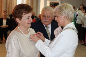 Zdjęcie przedstawia Burmistrza Miasta i Gminy Osjaków wręczającą medal za długoletnie pożycie małżeńskie Prezydenta Rzeczpospolitej Polskiej jubilatom