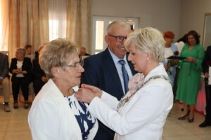 Zdjęcie przedstawia Burmistrza Miasta i Gminy Osjaków wręczającą medal za długoletnie pożycie małżeńskie Prezydenta Rzeczpospolitej Polskiej jubilatom