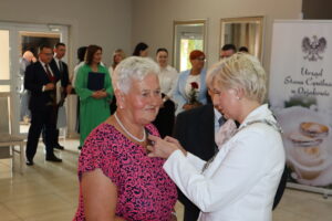 Zdjęcie przedstawia Burmistrza Miasta i Gminy Osjaków wręczającą medal za długoletnie pożycie małżeńskie Prezydenta Rzeczpospolitej Polskiej jubilatom