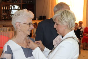 Zdjęcie przedstawia Burmistrza Miasta i Gminy Osjaków wręczającą medal za długoletnie pożycie małżeńskie Prezydenta Rzeczpospolitej Polskiej jubilatom
