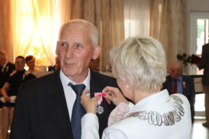 Zdjęcie przedstawia Burmistrza Miasta i Gminy Osjaków wręczającą medal za długoletnie pożycie małżeńskie Prezydenta Rzeczpospolitej Polskiej jubilatom