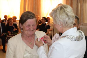 Zdjęcie przedstawia Burmistrza Miasta i Gminy Osjaków wręczającą medal za długoletnie pożycie małżeńskie Prezydenta Rzeczpospolitej Polskiej jubilatom