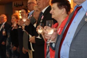 Zdjęcie przedstawia jubilatów trzymających kieliszki z szampanem